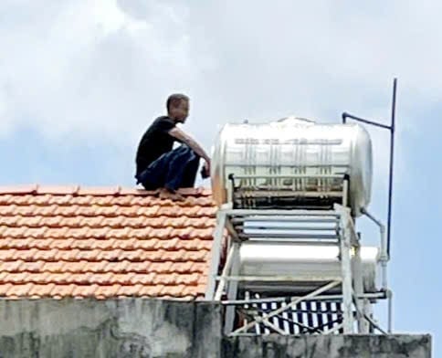 TP HCM: Người đàn ông cầm dao leo lên nóc nhà khiến người dân hoảng sợ- Ảnh 1.