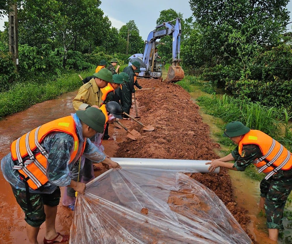Cán bộ, chiến sĩ Ban Chỉ huy phòng thủ khu vực 3 Tân Yên và dân quân gia cố đê chống tràn..jpg