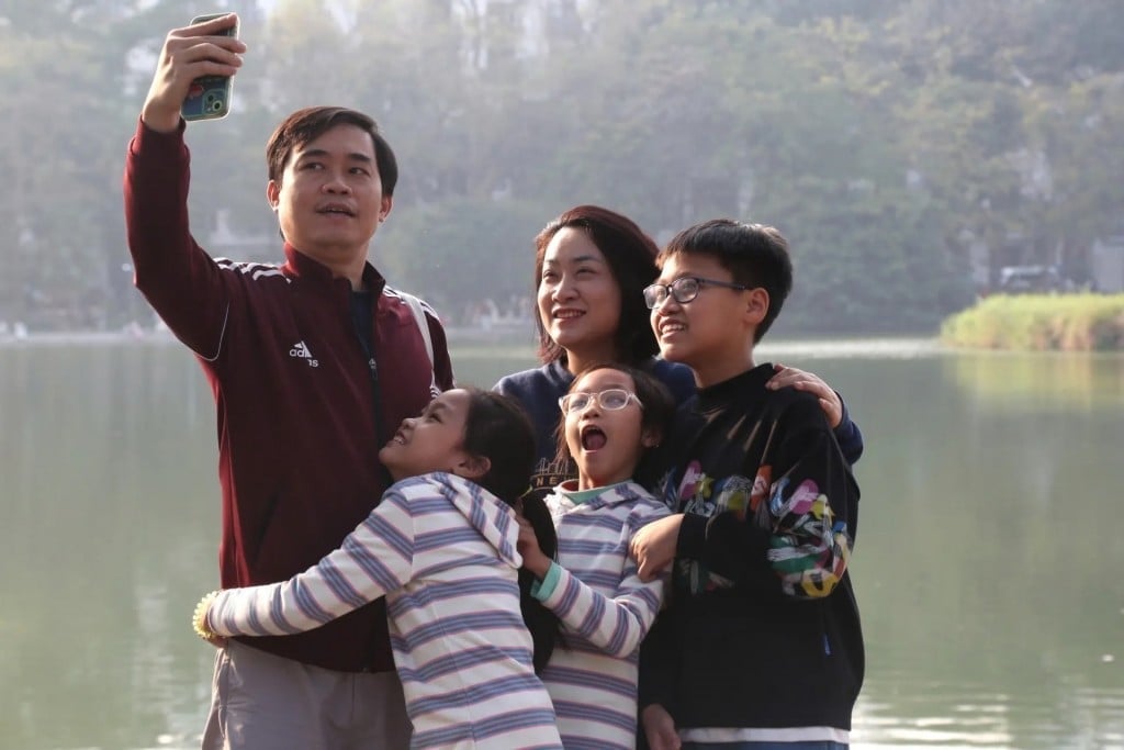 Một gia đình nhỏ lưu lại khoảnh khắc hạnh phúc bên bờ hồ Hoàn Kiếm. Ảnh Tuyết Linh