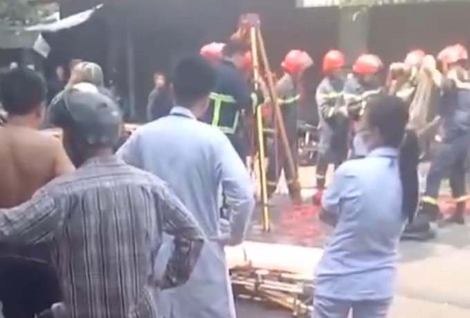 Lực lượng cứu hộ đưa hai nạn nhân ra khỏi hố ga. Ảnh: Người dân cung cấp